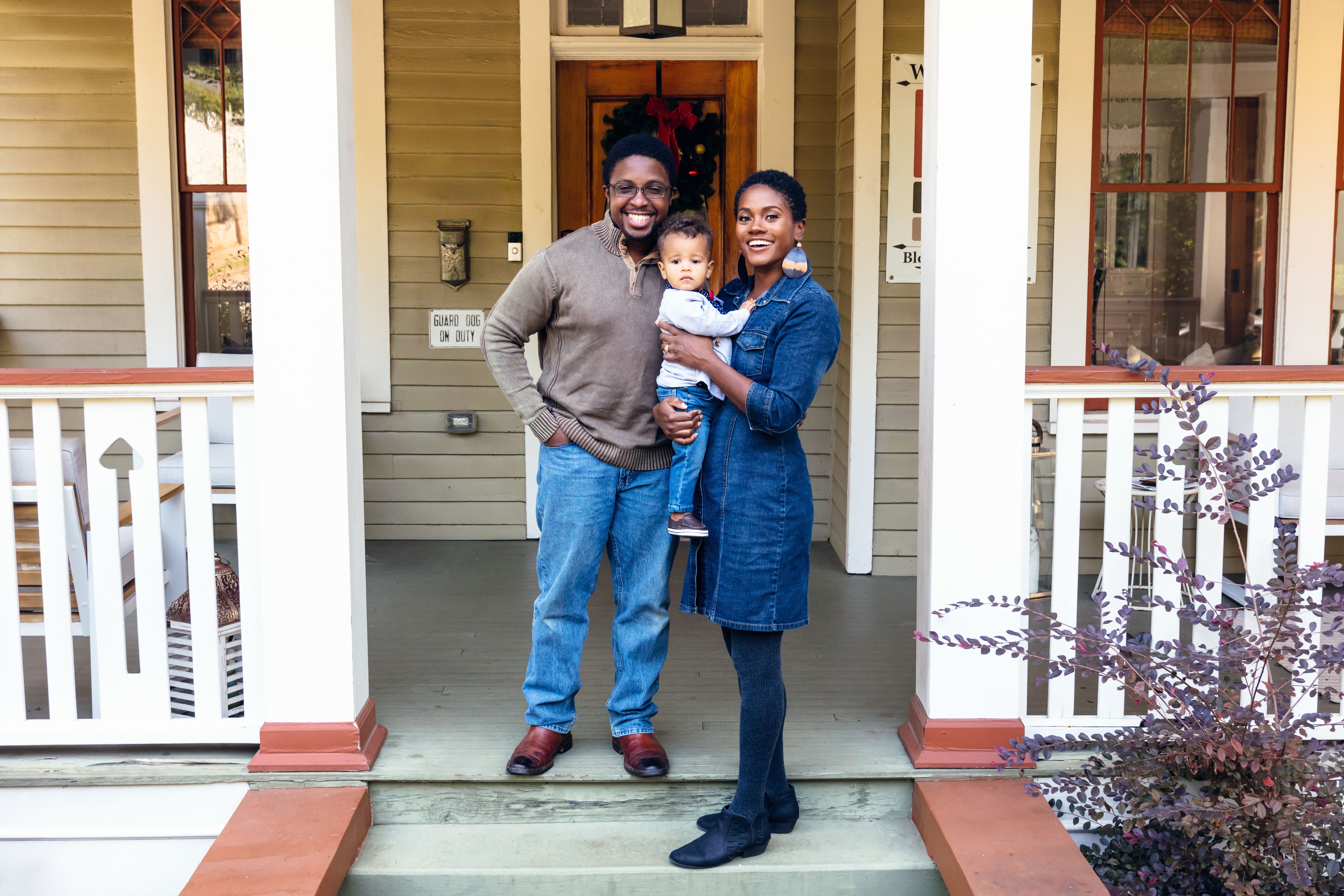 Portrait of black family and child in front of home for the holidays.
